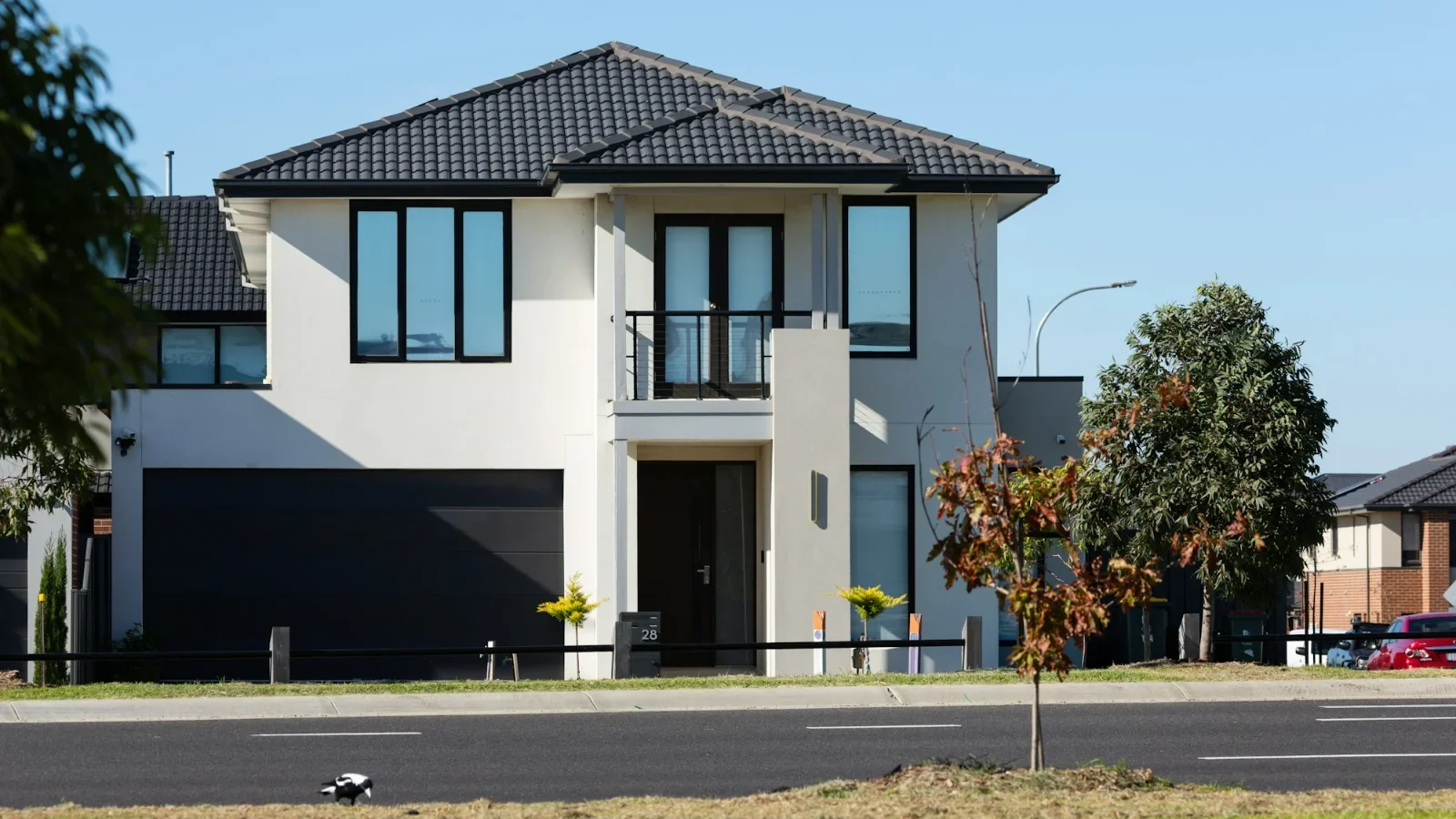Wide dark double garage door on a modern two-story home, representing residential garage door repair and installation marketing